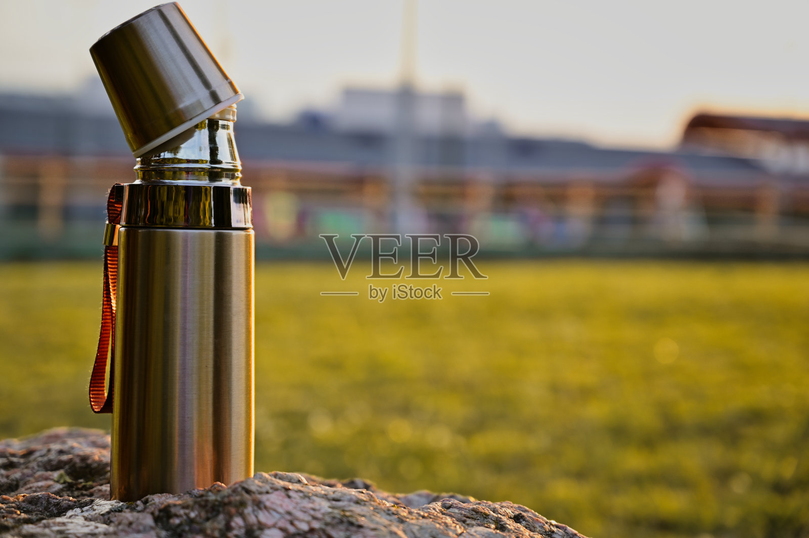 照片上的热水瓶休息在夕阳的背景。美丽的阳光照片摄影图片