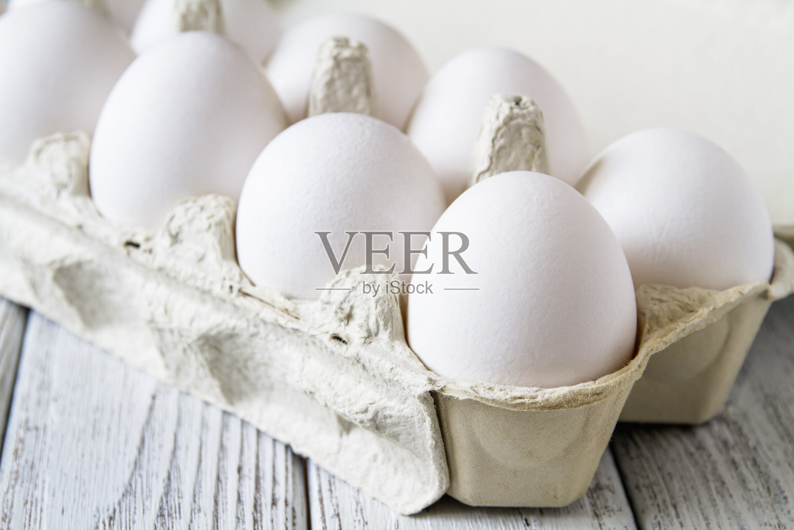 特写的新鲜的白色有机鸡蛋在纸托盘上轻木制背景照片摄影图片