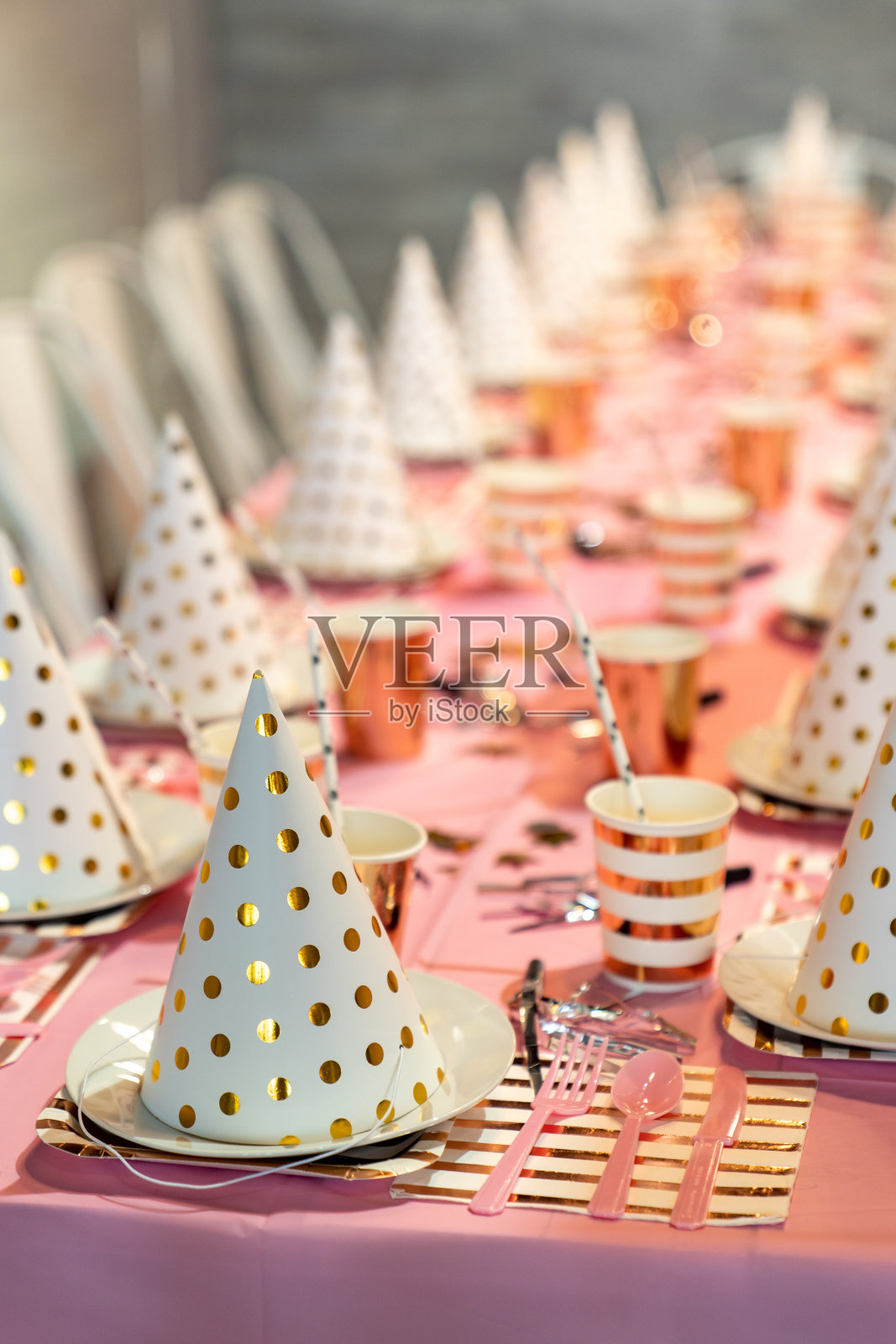 儿童餐桌装饰节日帽子和杯子。小女孩的生日。照片摄影图片