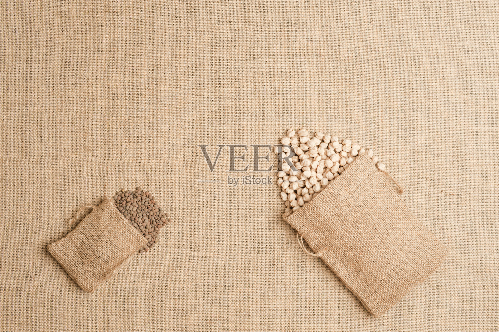 纹理或背景为棕色麻布袋，亚麻袋和扁豆和鹰嘴豆。俯视图照片摄影图片