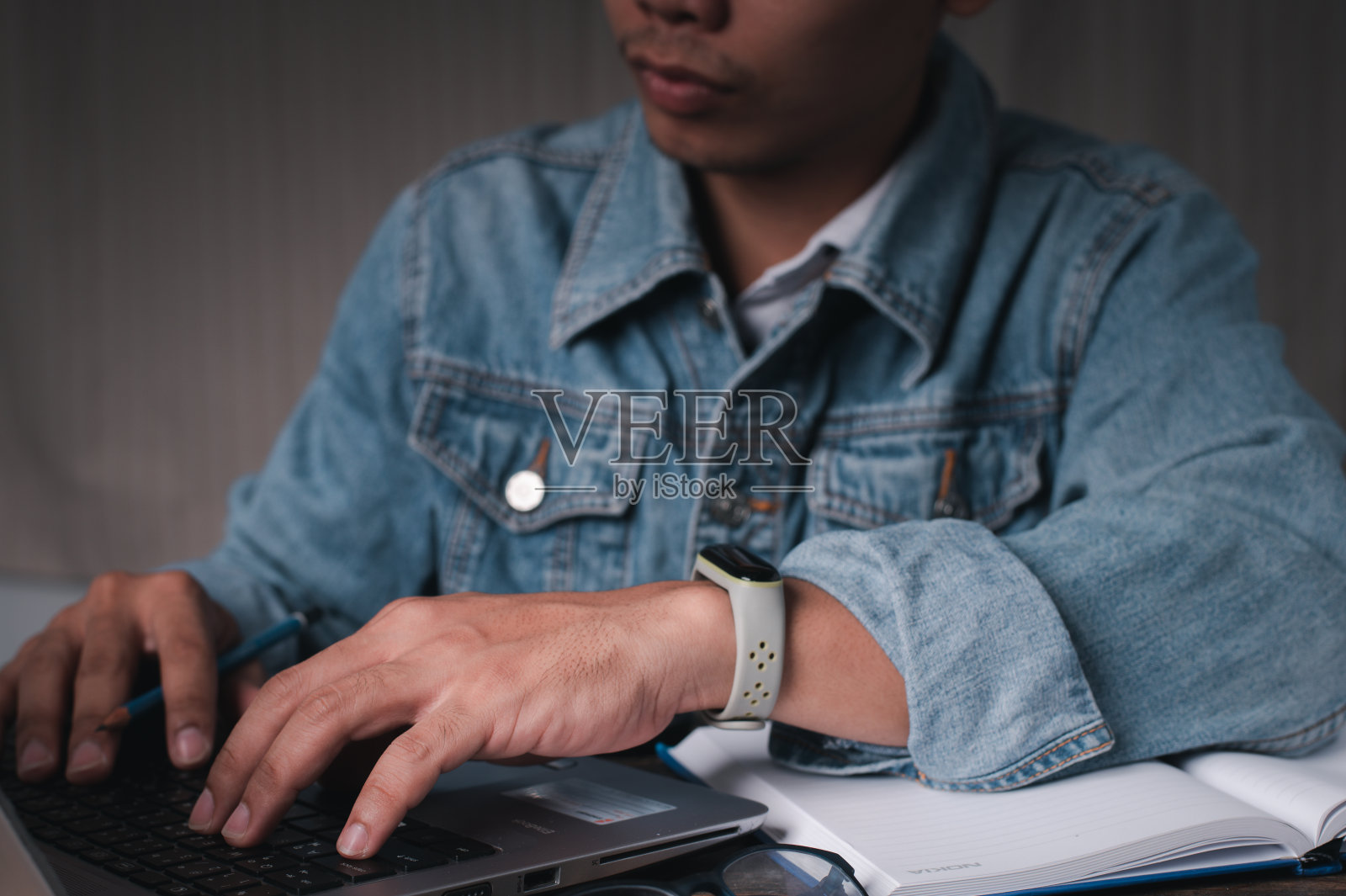 一个人坐着用笔记本工作。概念在家里工作，概念在办公室工作。照片摄影图片