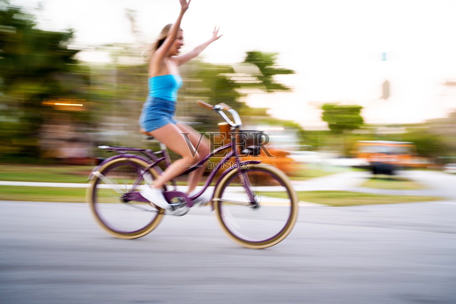 年轻女子骑着自行车在附近移动照片摄影图片
