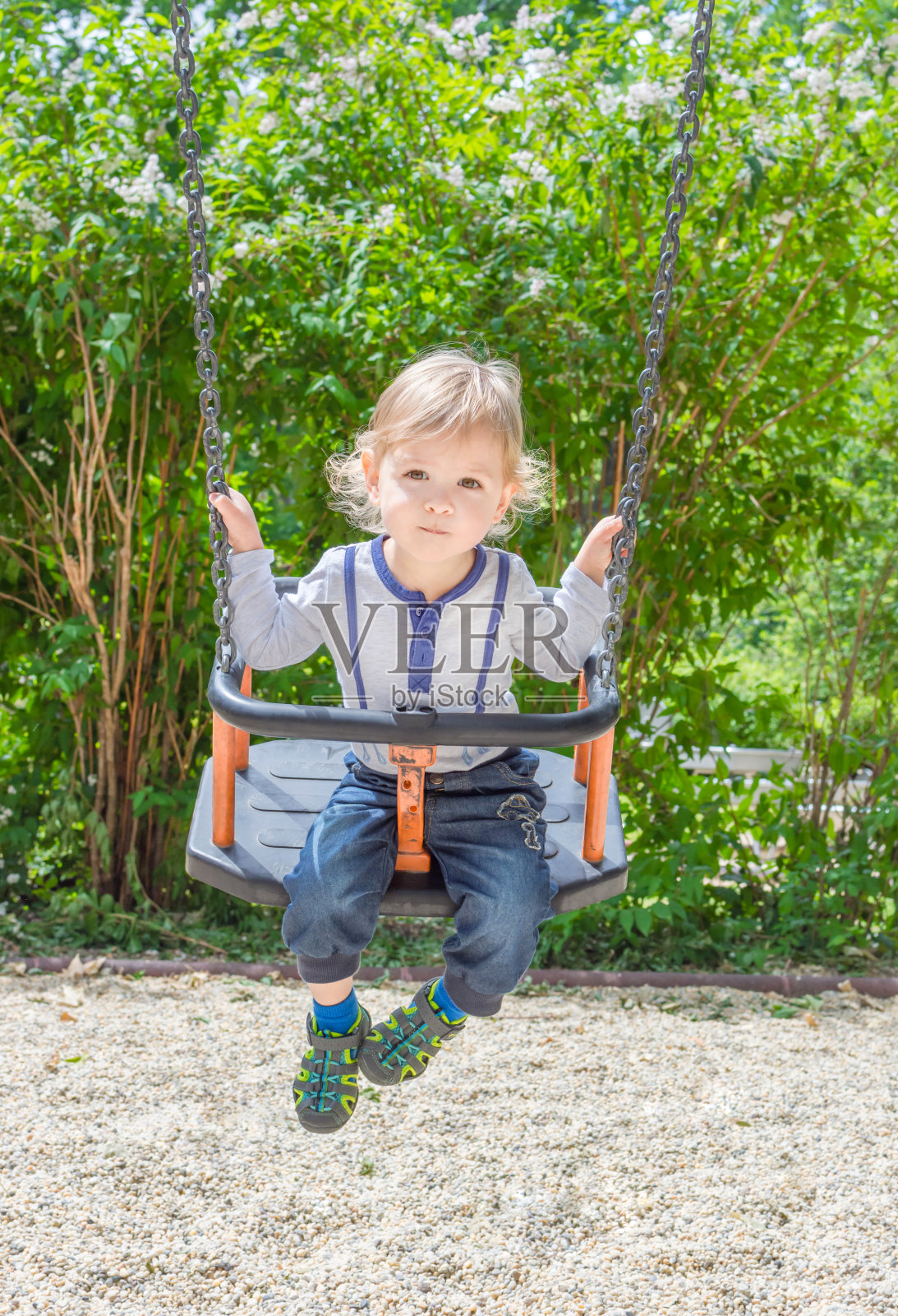 可爱的小孩在公园里荡秋千玩得很开心。美丽的夏日阳光明媚，在儿童游乐场照片摄影图片