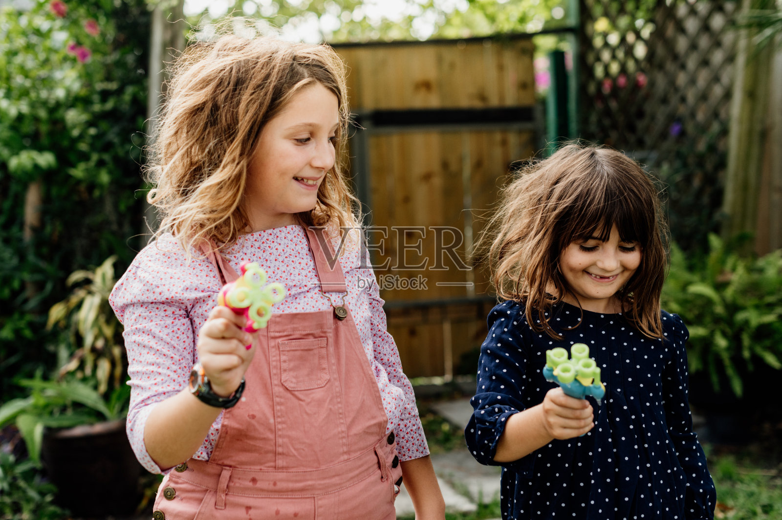 两个孩子在后院玩泡泡，快乐的童年照片摄影图片