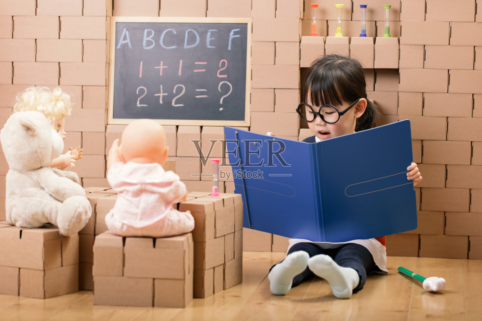 蹒跚学步的小女孩在家里扮演老师照片摄影图片