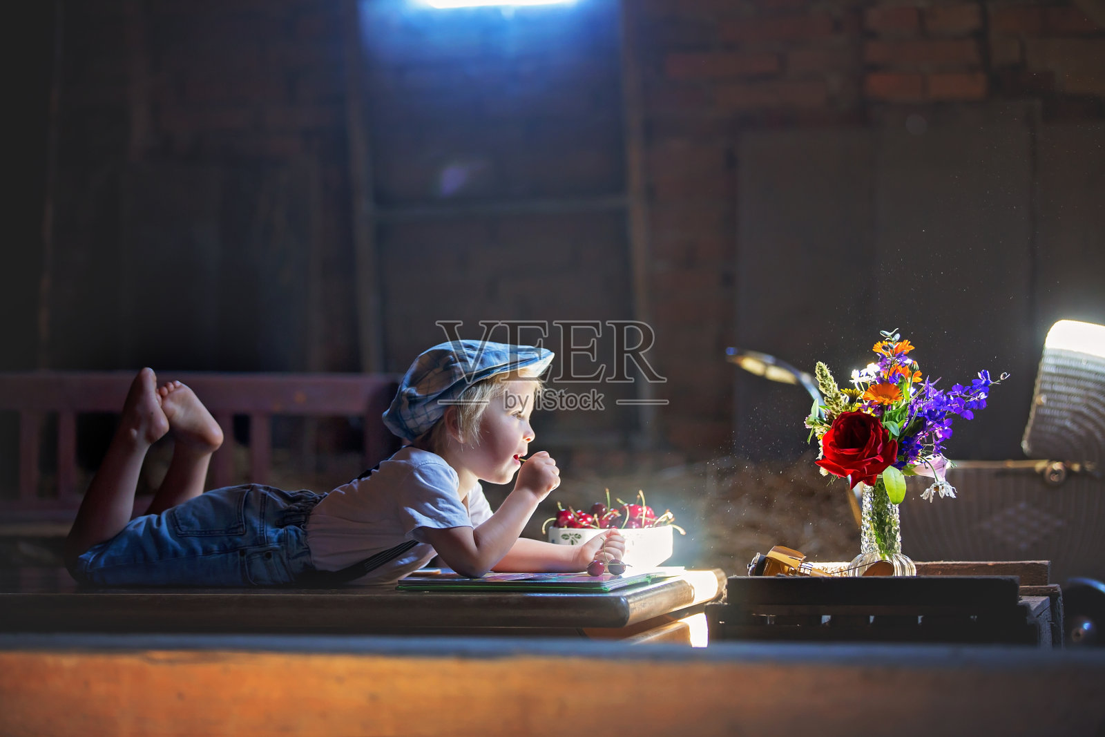 可爱漂亮的孩子，金发碧眼的孩子，在舒适的阁楼房间里读书和玩积木照片摄影图片