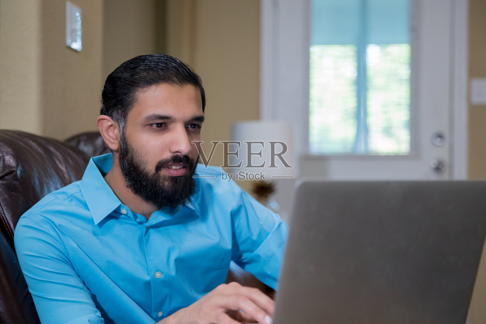 商人使用笔记本电脑在家远程工作照片摄影图片