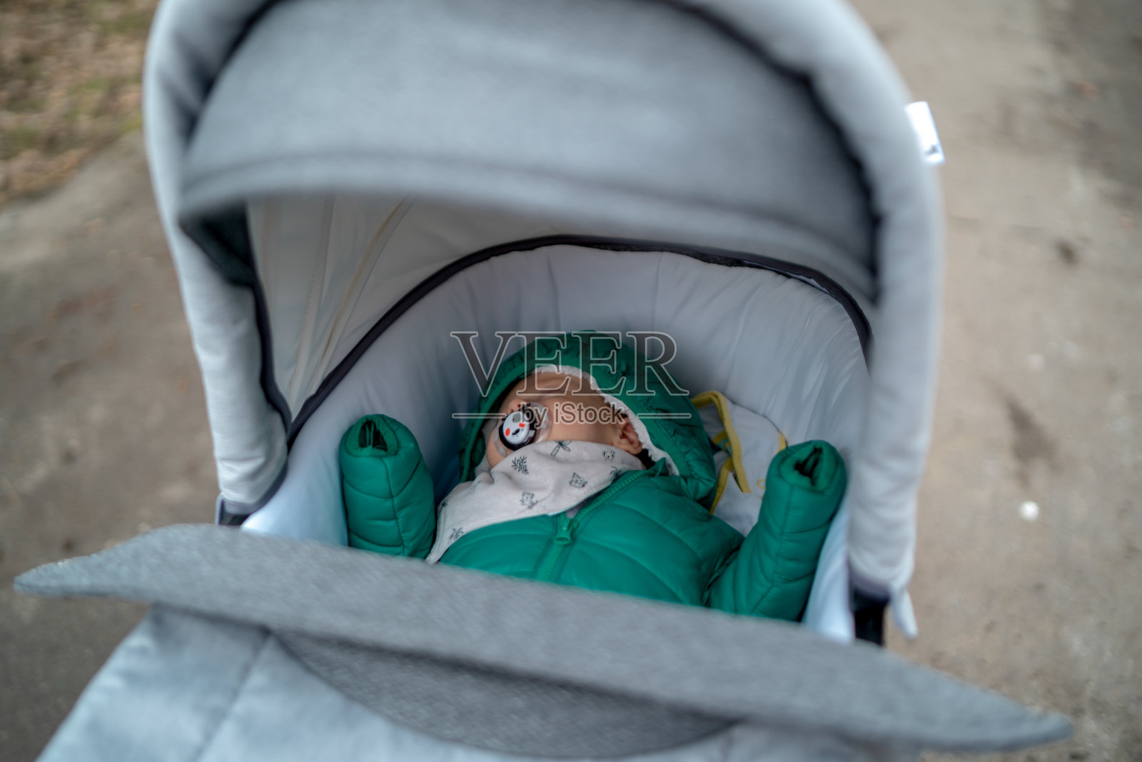 妈妈推着婴儿车在树林里散步照片摄影图片