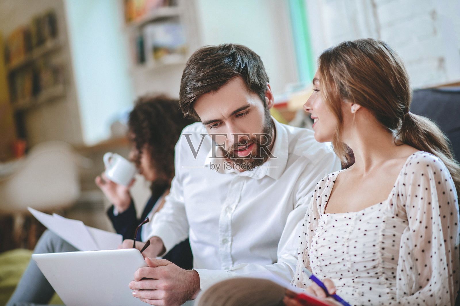 一个细心的男人在看文件，一个女孩在看他照片摄影图片