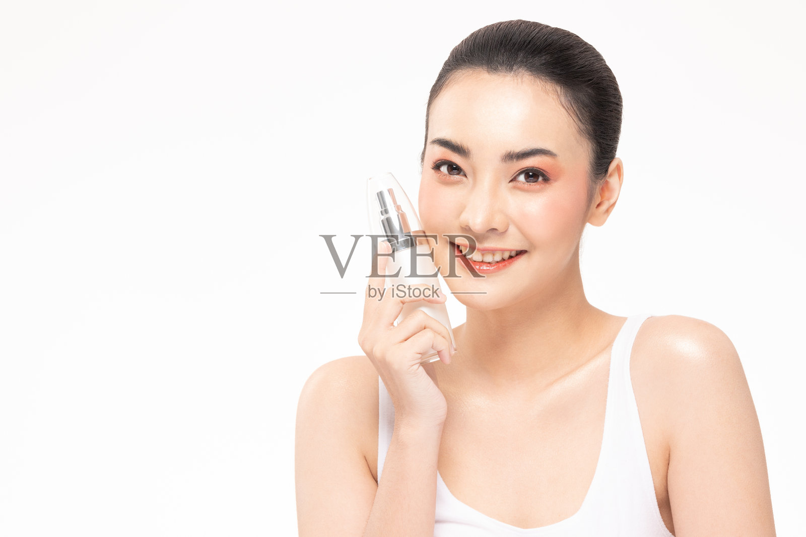 美丽的亚洲女人捧着护肤霜和爽朗的瓶子。照片摄影图片