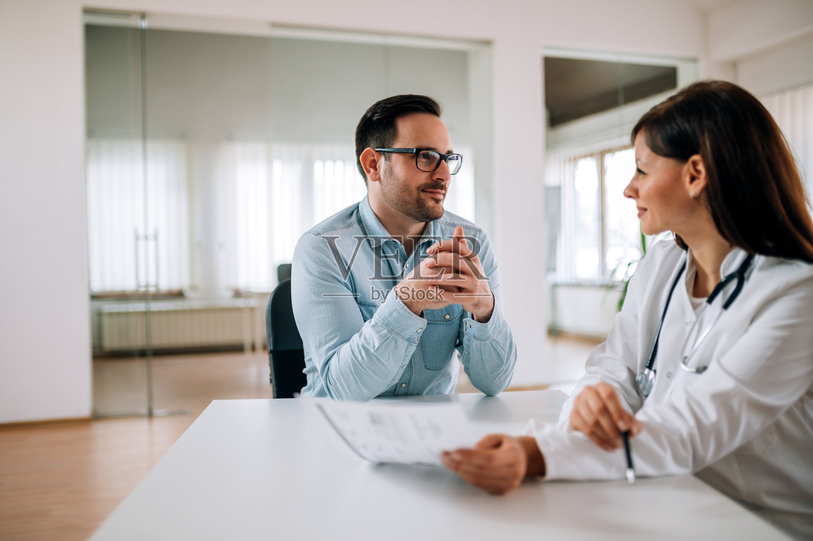 人，医疗理念。男人在和一个漂亮的女医生做体检。照片摄影图片