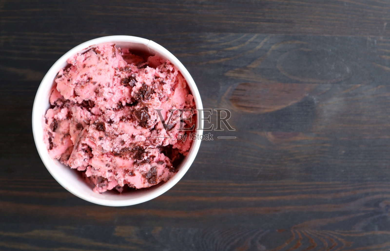 一杯美味的奶油草莓巧克力块冰淇淋在深棕色的木头背景照片摄影图片