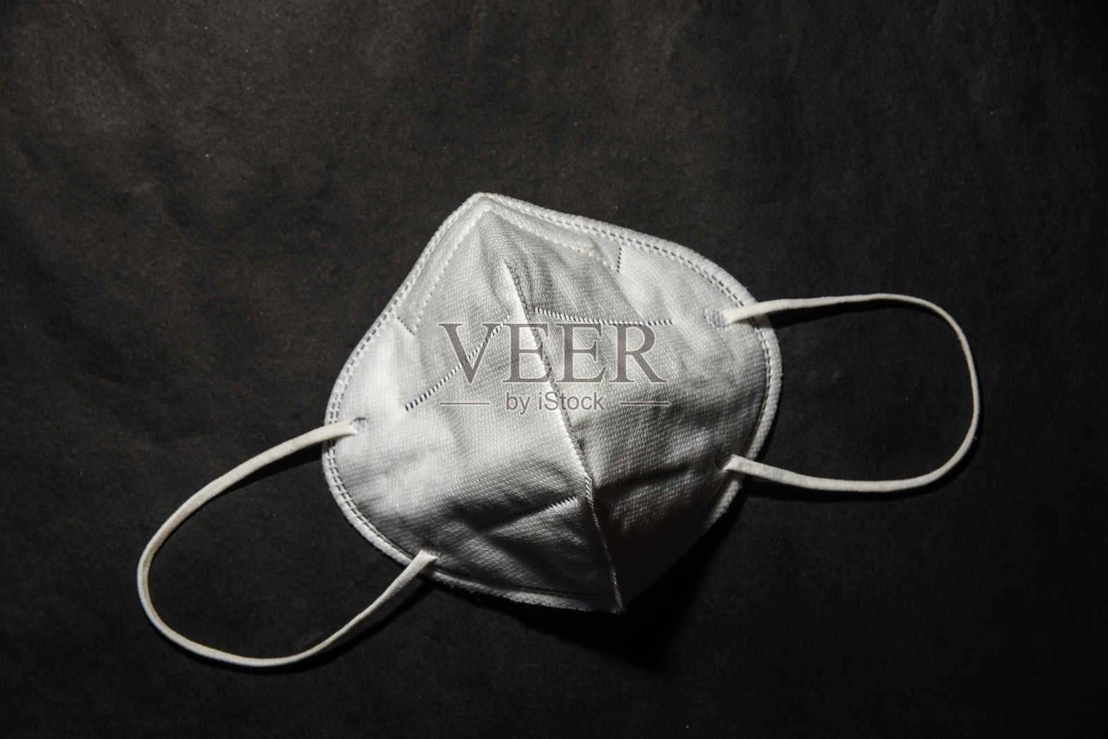 带橡胶耳带的外科口罩。典型的三层外科口罩，用以覆盖口鼻。防止细菌滋生。保护的概念。照片摄影图片