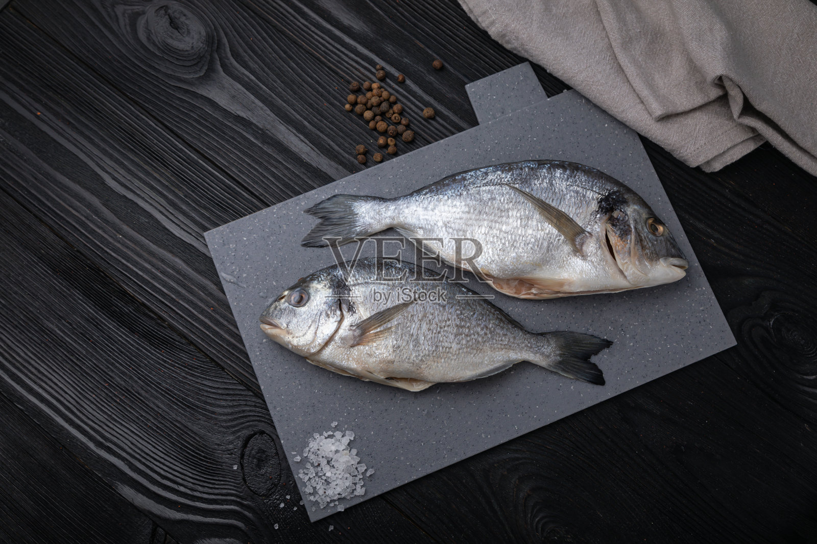 灰色板上放着加盐和胡椒的多拉达照片摄影图片