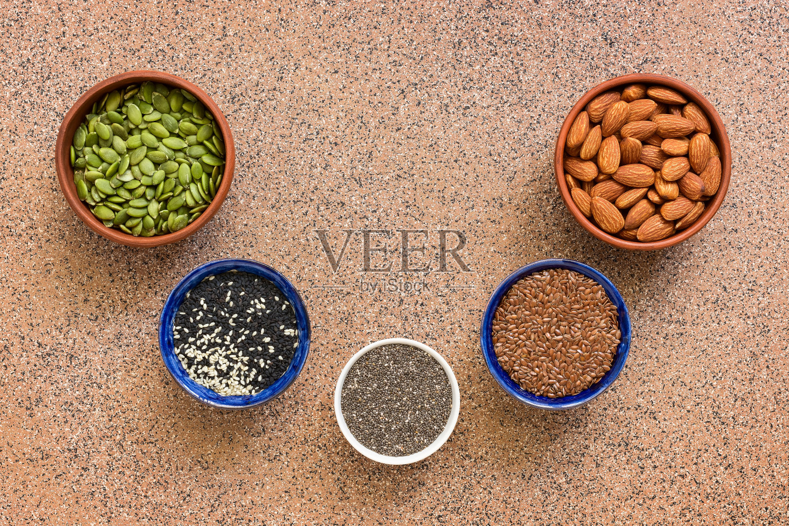 半圆形框架内装各种种子。芝麻，亚麻，奇亚，南瓜，杏仁。俯视图，平放，复制空间。照片摄影图片