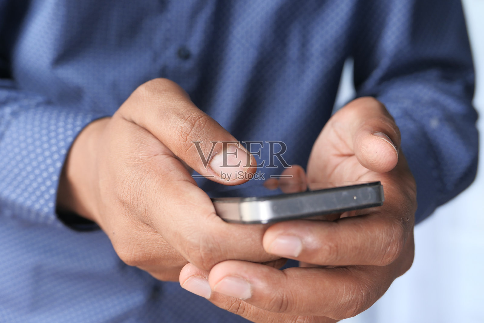 年轻人的手使用智能手机的特写照片摄影图片