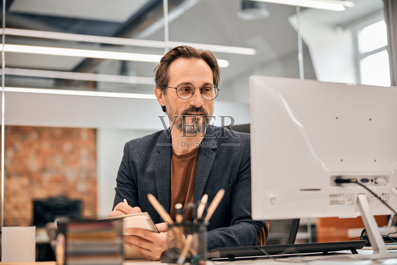 穿着黑色夹克在白色办公室工作的男性照片摄影图片