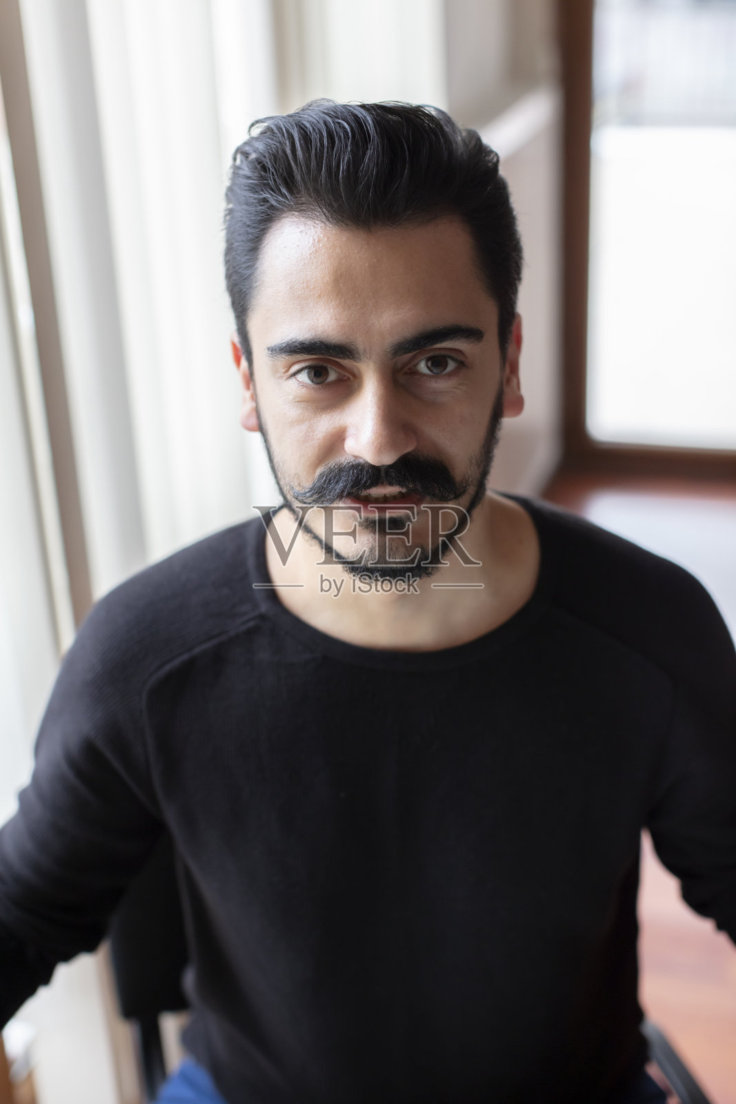 面带微笑看向镜头的年轻胡须男照片摄影图片