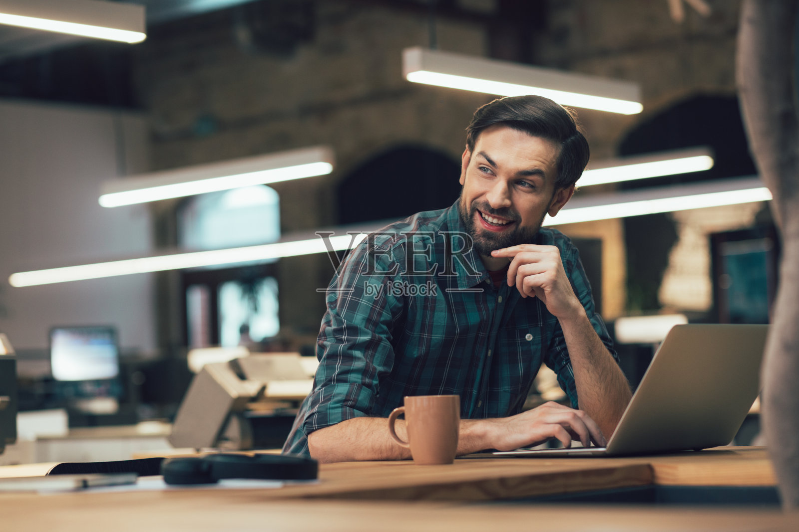 好奇的年轻人微笑着，享受着他的工作日照片摄影图片