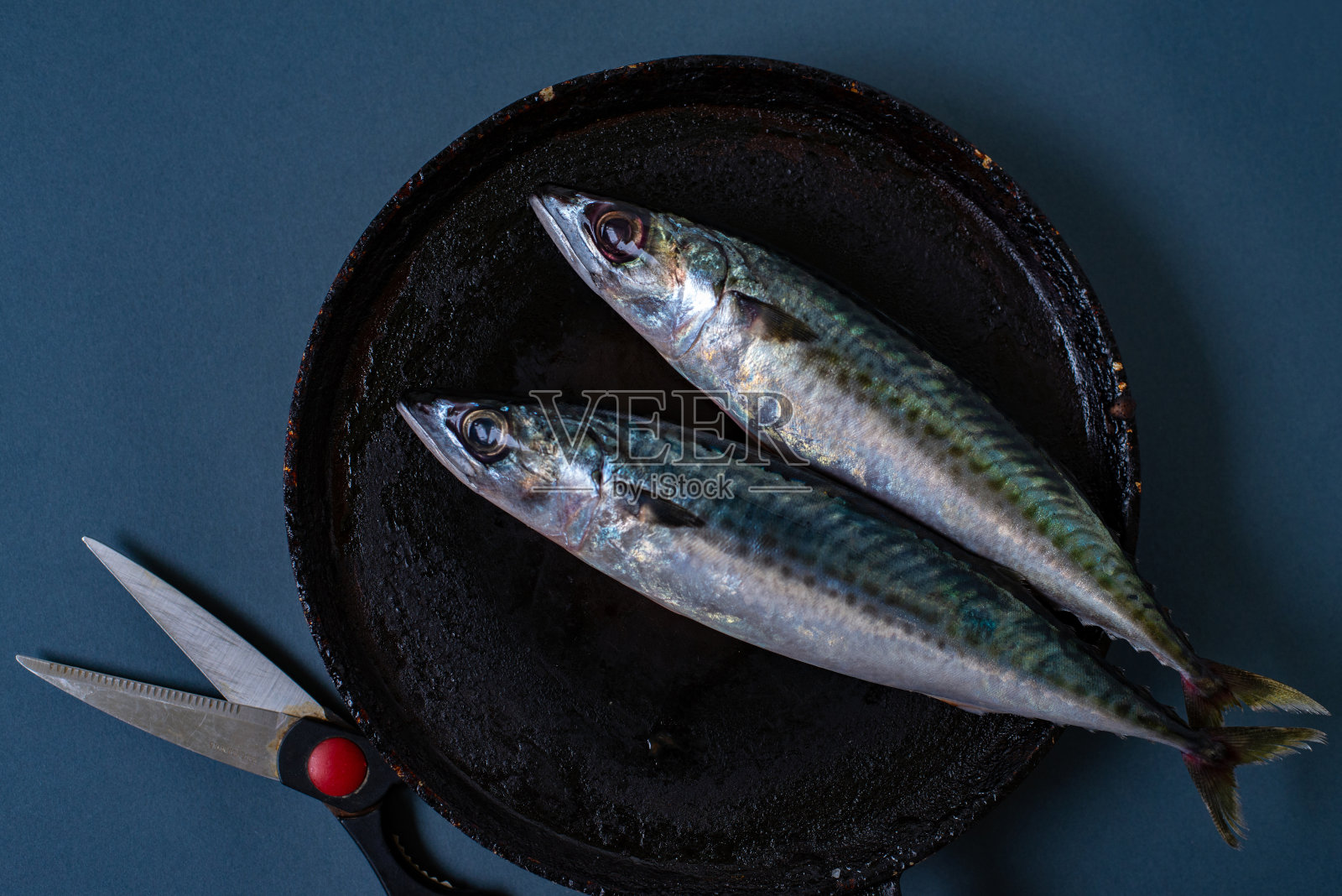 漂亮的摄影，煎锅里的两条鱼照片摄影图片