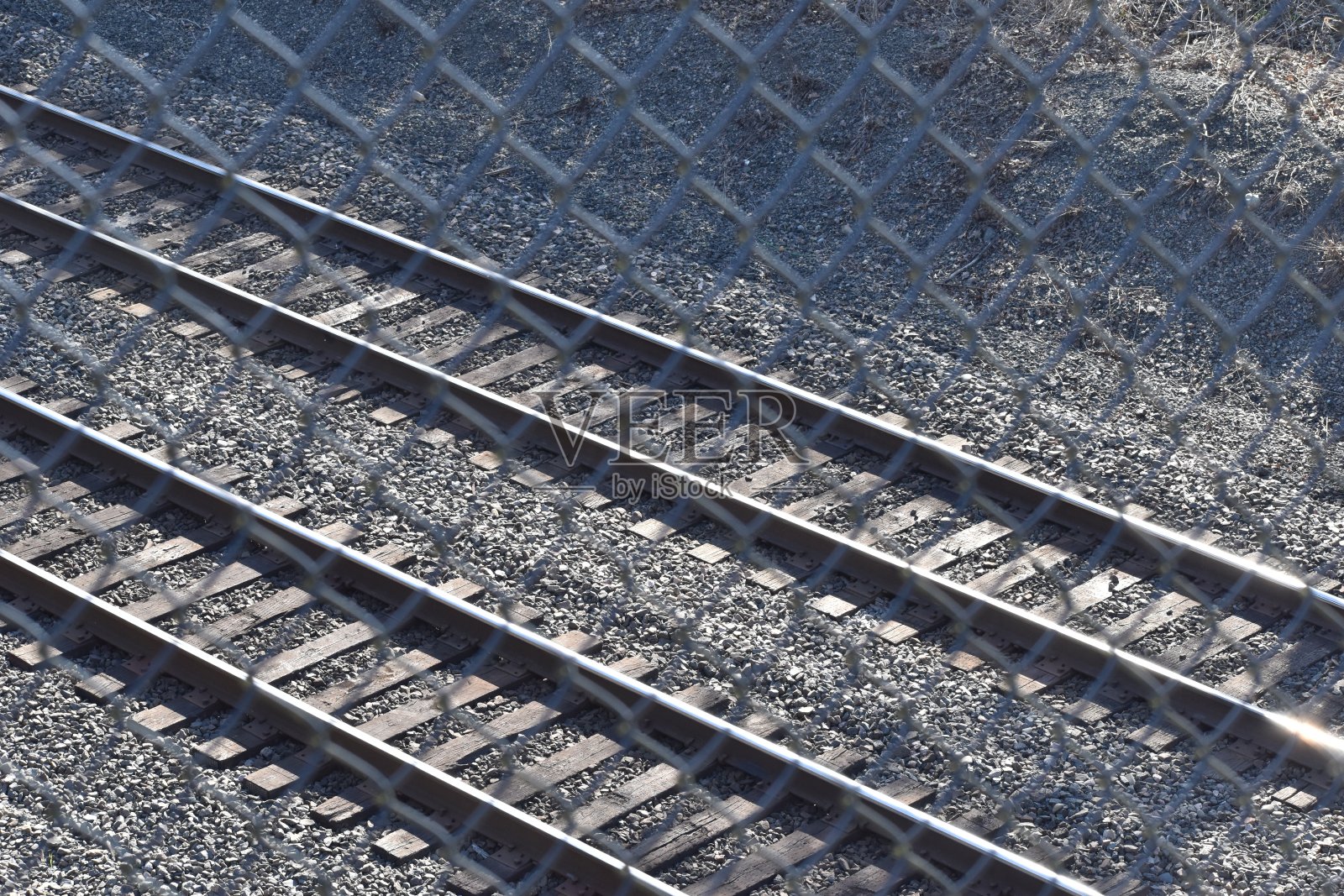 两条平行的铁轨上有铁链围栏。照片摄影图片