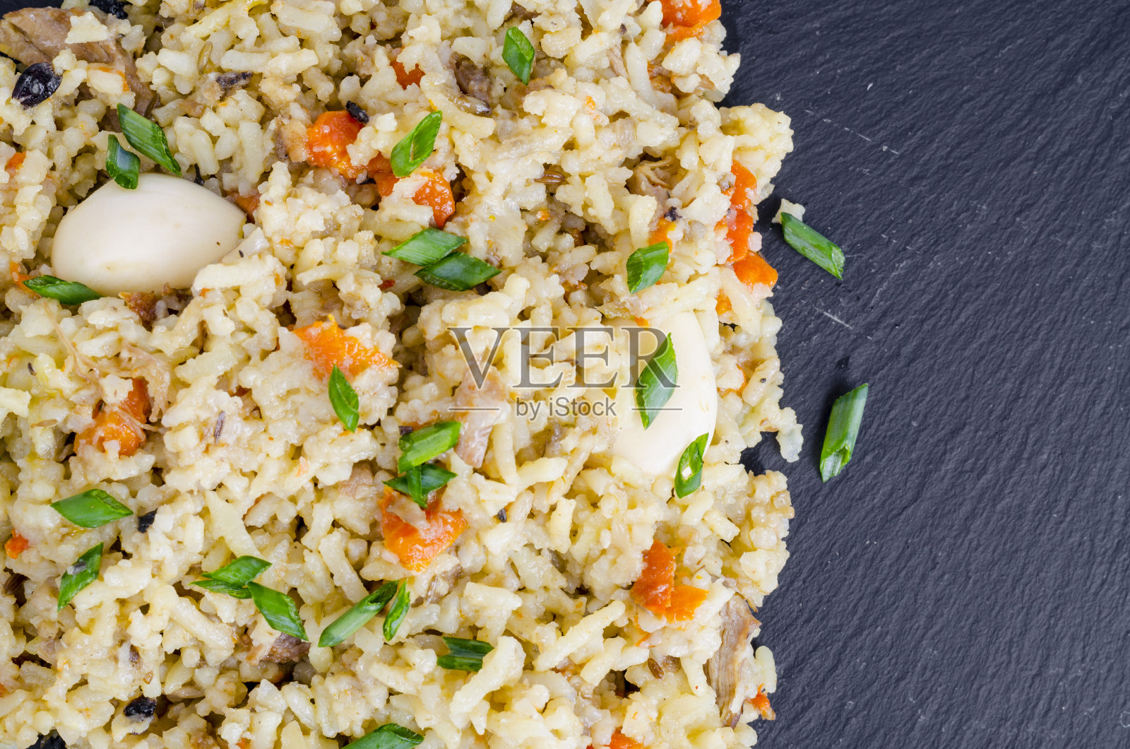 一串美味的金色肉饭放在黑石头上照片摄影图片