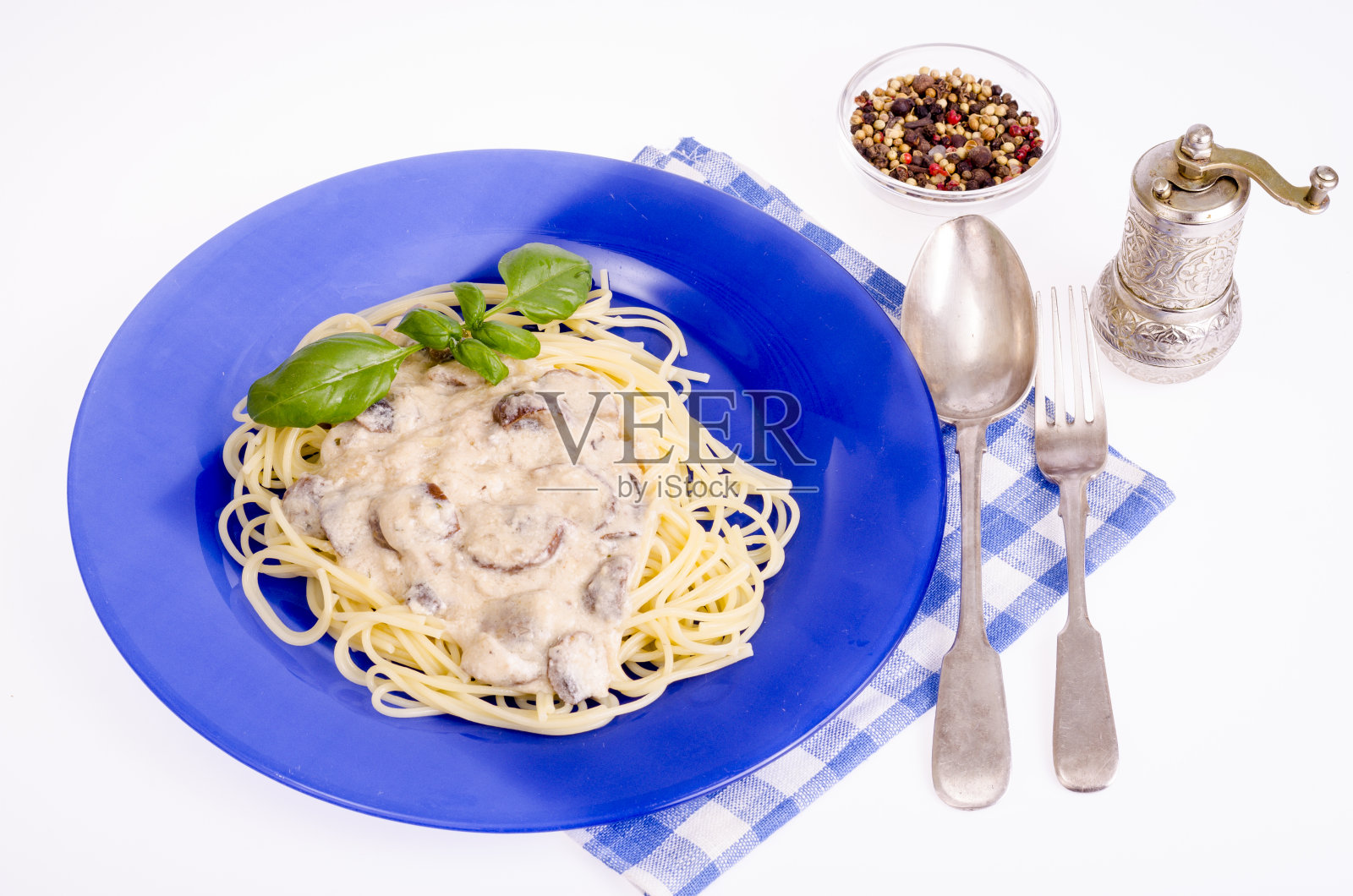蓝色盘子，配意大利面和蘑菇酱。照片摄影图片