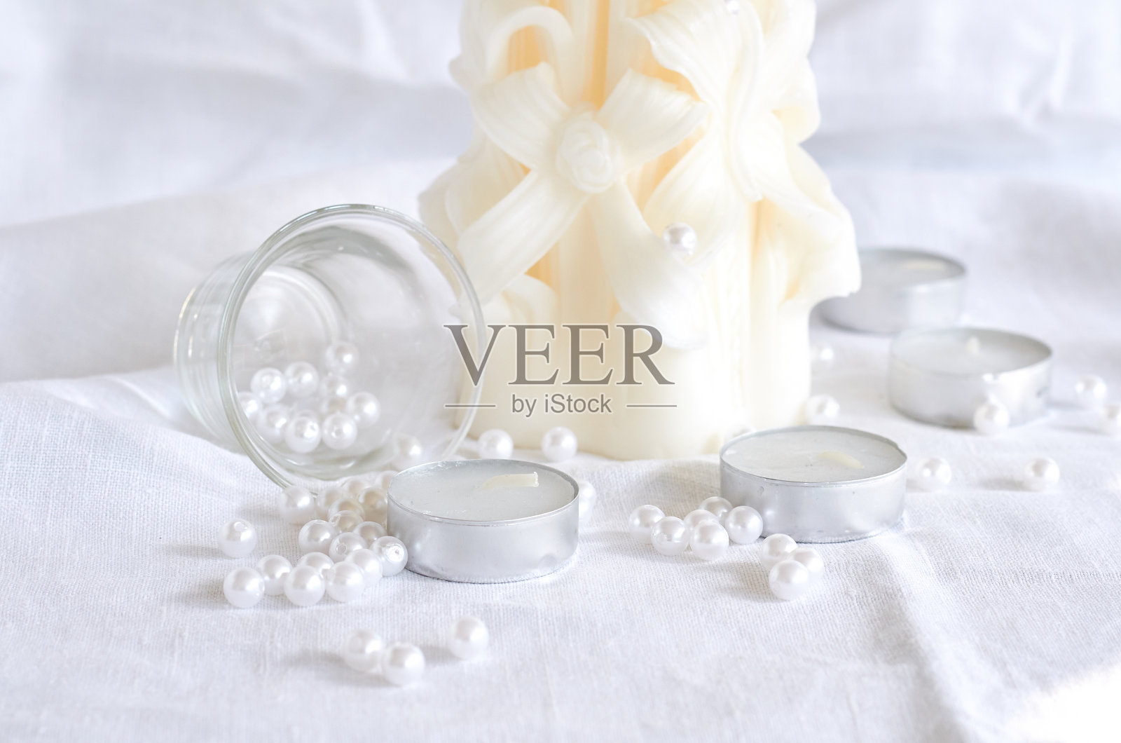 蜡烛，白色的珠子和玻璃碗里的阴影照片摄影图片