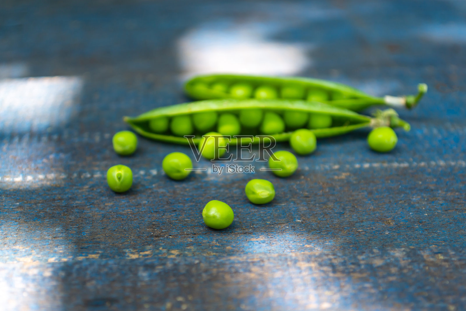 蓝色背景上的豌豆荚照片摄影图片