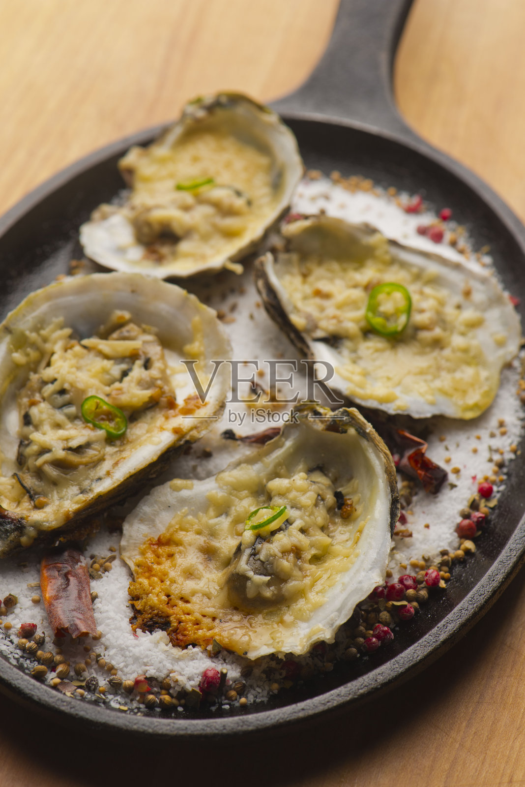 洛克菲勒牡蛎新鲜的牡蛎烤sautéed黄油，大蒜，葱，顶部的奶酪，鸡尾酒酱，木犀草酱和新鲜的柠檬和酸橙。经典的美国牛排或法式小酒馆开胃菜。照片摄影图片