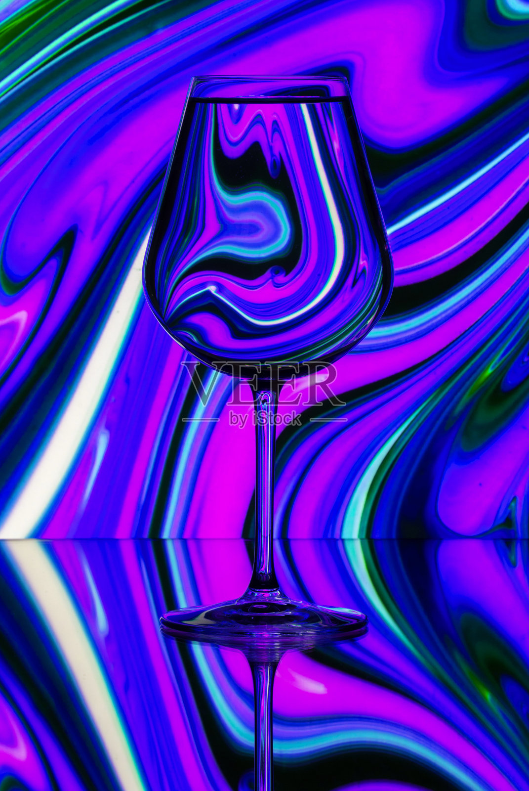 透过一杯水看到的图案扭曲。静物画照片摄影图片