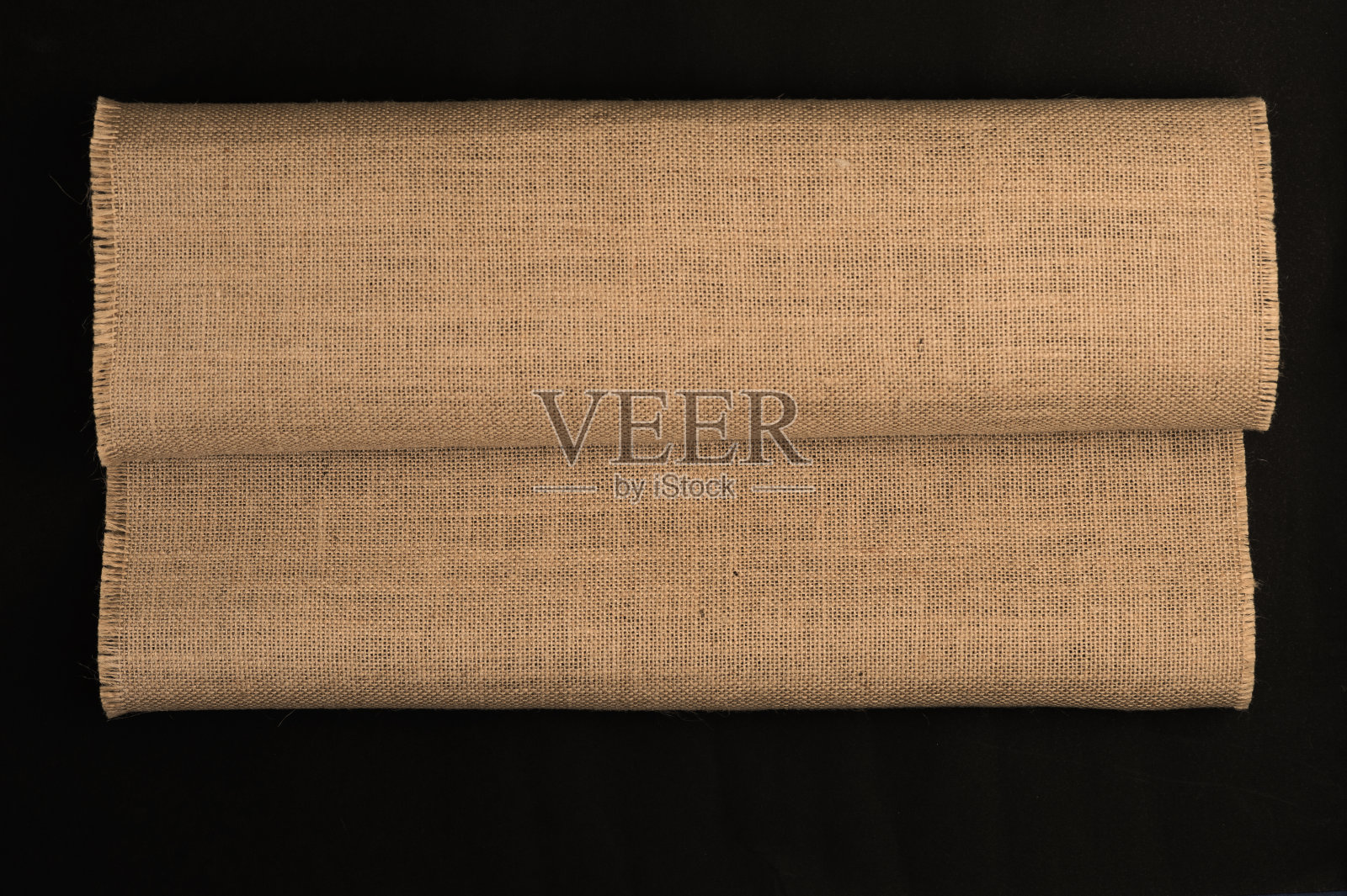 天然亚麻纹理卷起来，黑色背景。俯视图照片摄影图片