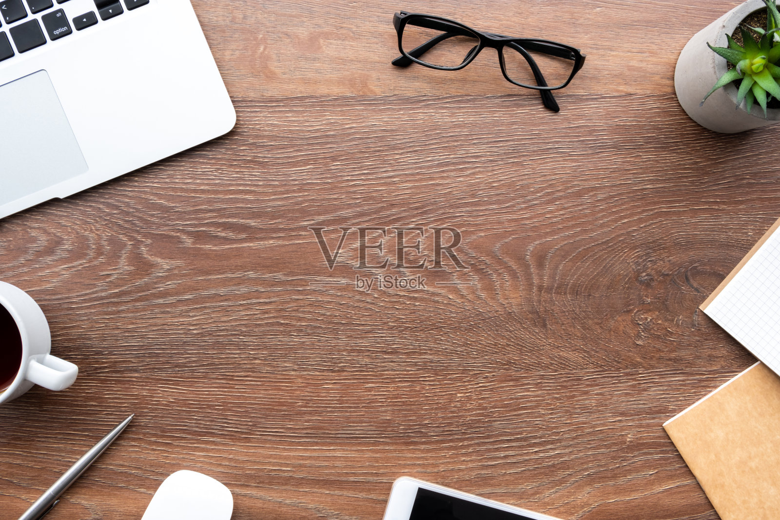 木制办公桌，桌子上有笔记本电脑，智能手机和办公用品。顶视图与复制空间，平放。照片摄影图片