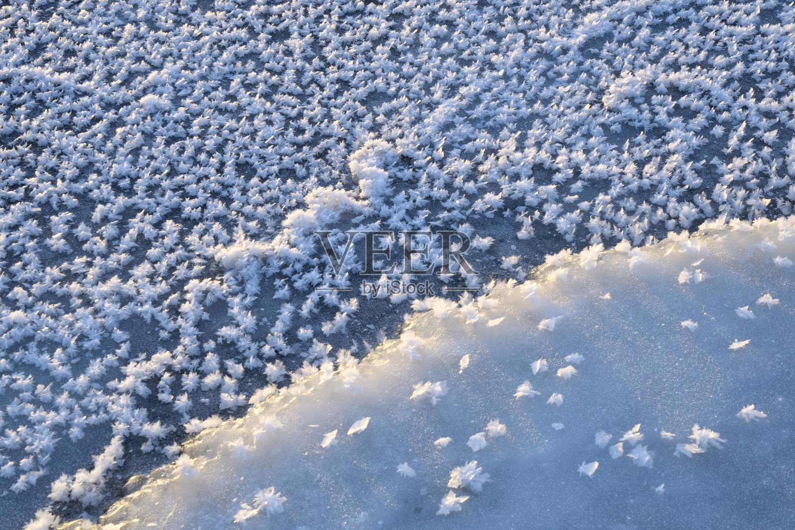 大朵的雪花落在河上蓝色的冰上照片摄影图片