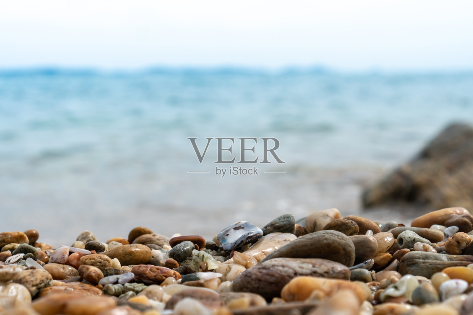 选择性聚焦于岩石纹理与模糊的海滩在背景显示产品。照片摄影图片