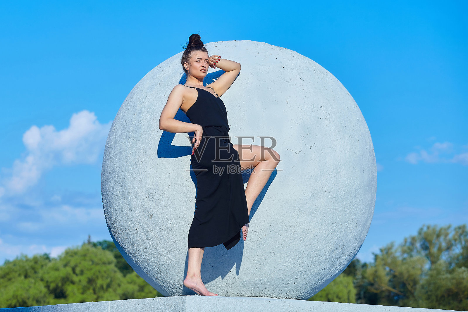 美丽的女孩与一个大气球对着天空摆姿势照片摄影图片