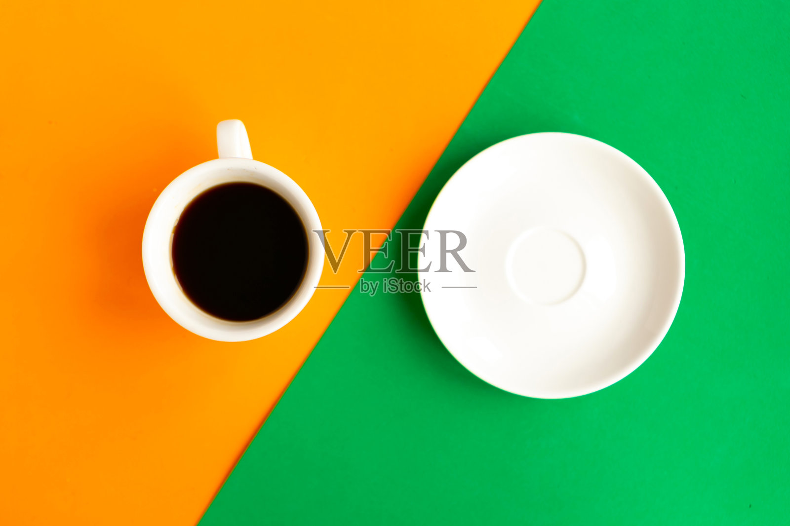 白色盘子和咖啡杯的几何橙色和绿色背景，俯视图。最小的概念照片摄影图片