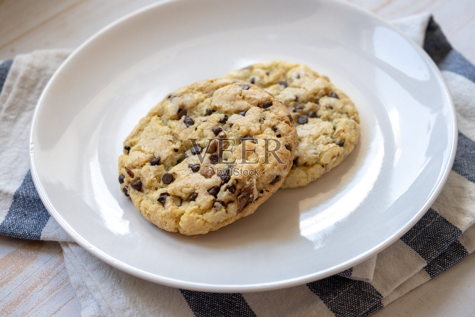 新鲜烘焙的经典巧克力饼干和坚果在盘子里照片摄影图片