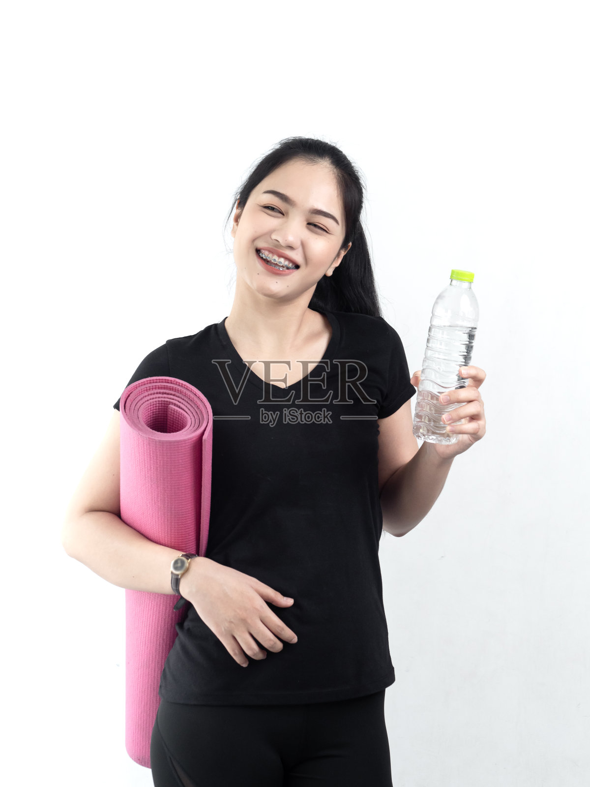 快乐的亚洲女人拿着一瓶水和粉色瑜伽垫，生活方式照片摄影图片
