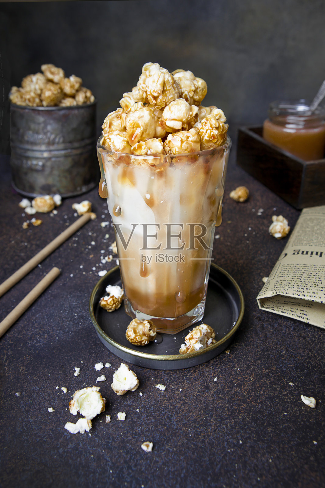 甜咸焦糖爆米花奶昔，焦糖，牛奶，复古深色背景，饮料照片摄影图片
