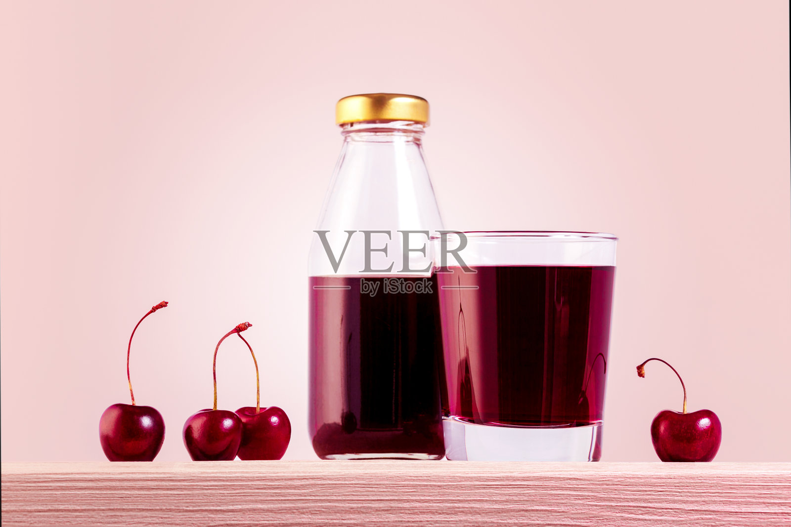玻璃和瓶子里的天然樱桃汁和甜樱桃放在木桌上。照片摄影图片