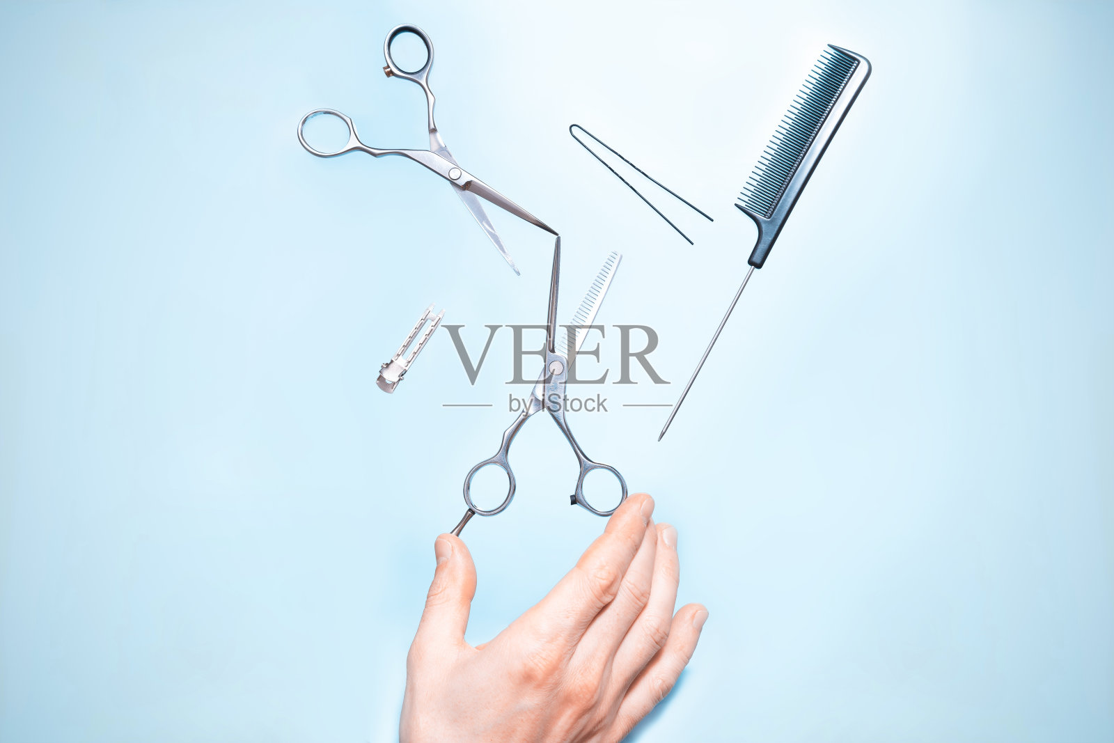 有拿着飞天发型师工具的梳子、剪刀，在时尚的色彩背景下配合拷贝空间和柔和的光线。时尚专业理发剪刀，发型师沙龙概念，理发配件照片摄影图片
