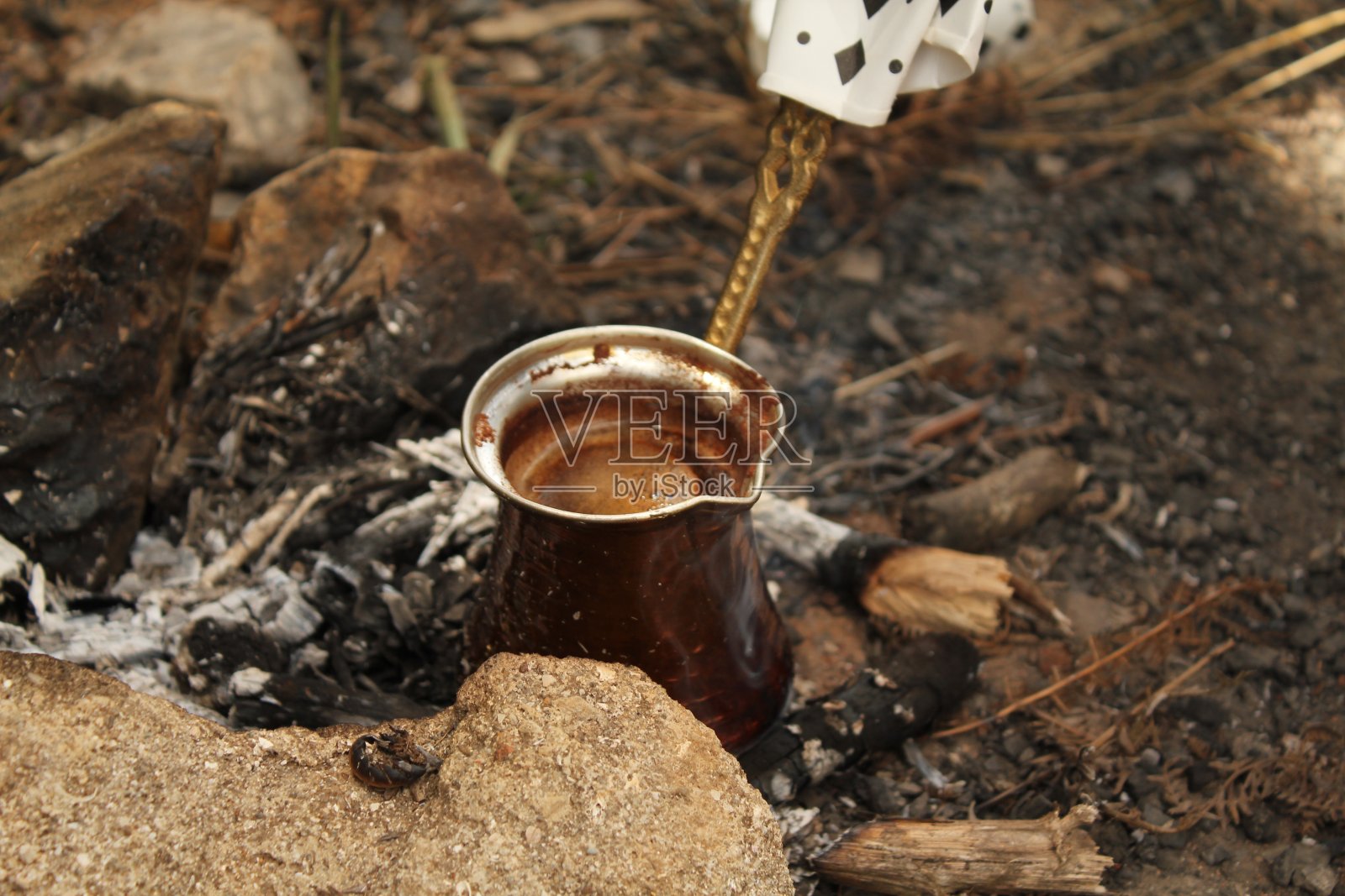 用木火煮土耳其咖啡，然后倒进杯子里的瞬间照片摄影图片