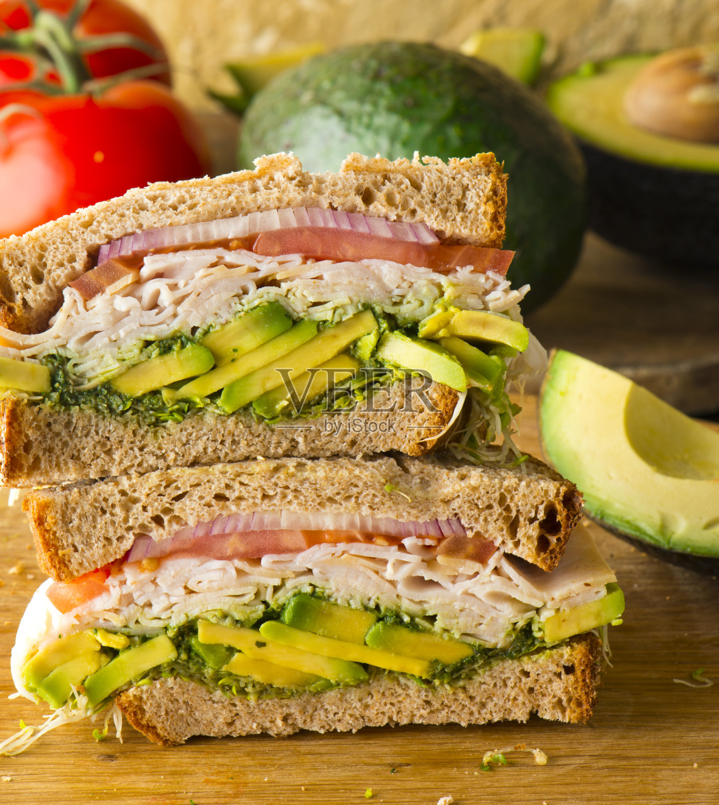 土耳其鳄梨三明治。火鸡三明治。牛油果切片配烤全麦面包，配瑞士奶酪、洋葱、生菜、番茄、蛋黄酱、调味盐和胡椒。经典美式餐厅或餐厅午餐三明治的最爱。照片摄影图片