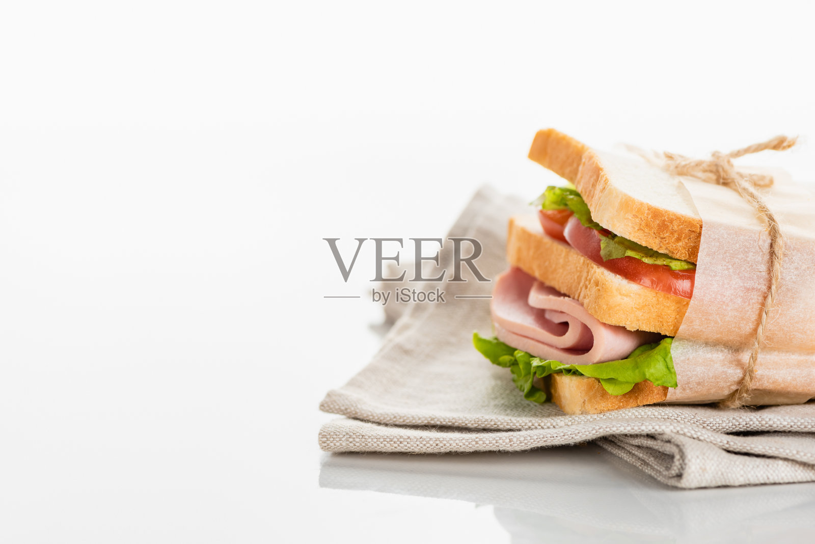 新鲜美味的三明治与切片香肠和生菜餐巾在白色的表面照片摄影图片