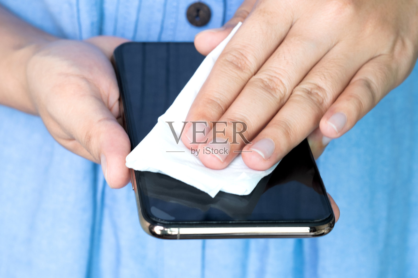 女人用衣服，防腐剂和病毒。她清洗了智能手机暴露是感染的原因。照片摄影图片