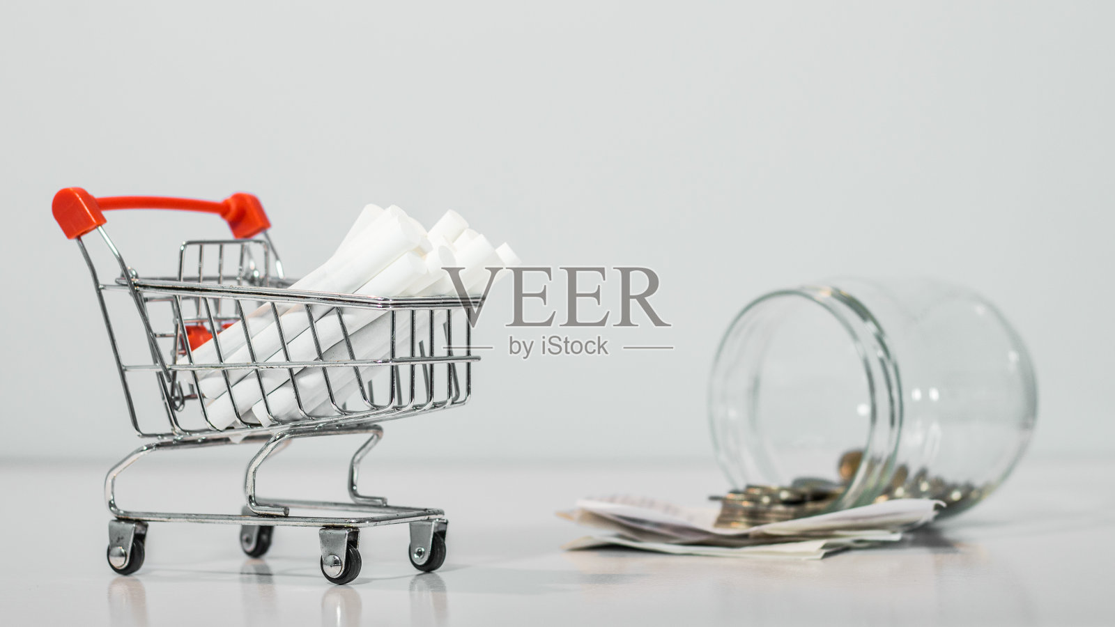 靠近迷你购物车上的香烟与钱包在白色背景与副本规格照片摄影图片