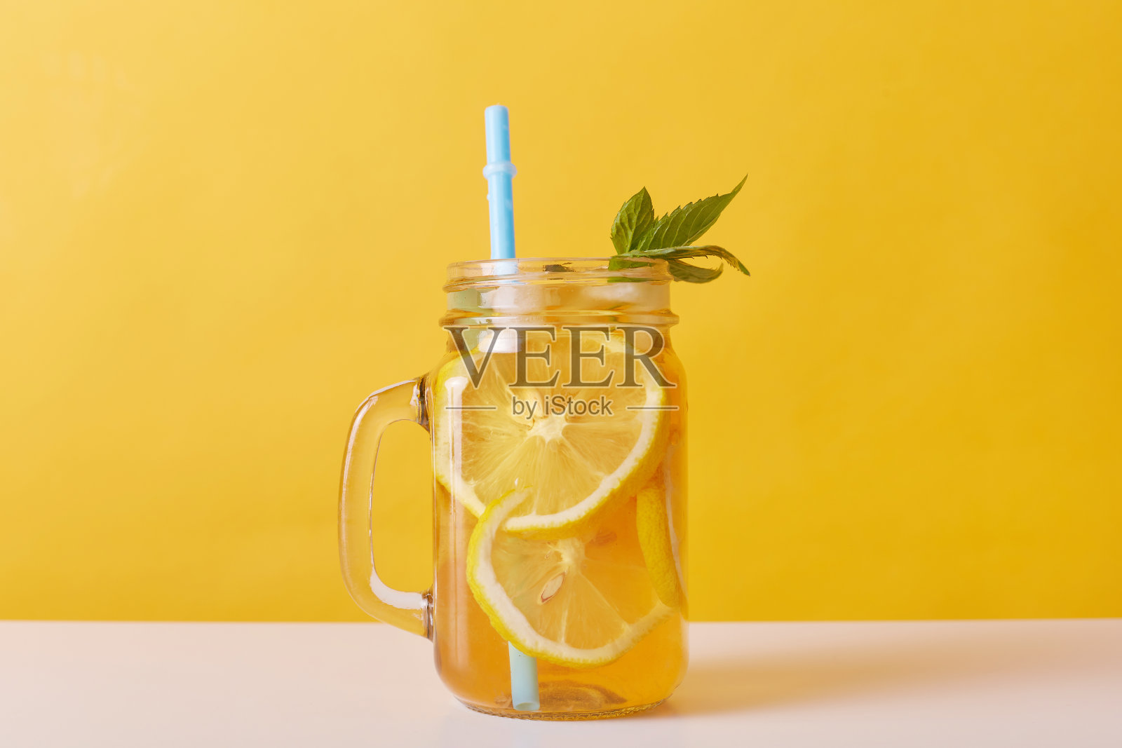 近距离拍摄的新鲜饮料与柠檬和薄荷，玻璃壶装满鸡尾酒和柠檬片和饮料管，寒冷的夏季清凉柠檬水。照片摄影图片