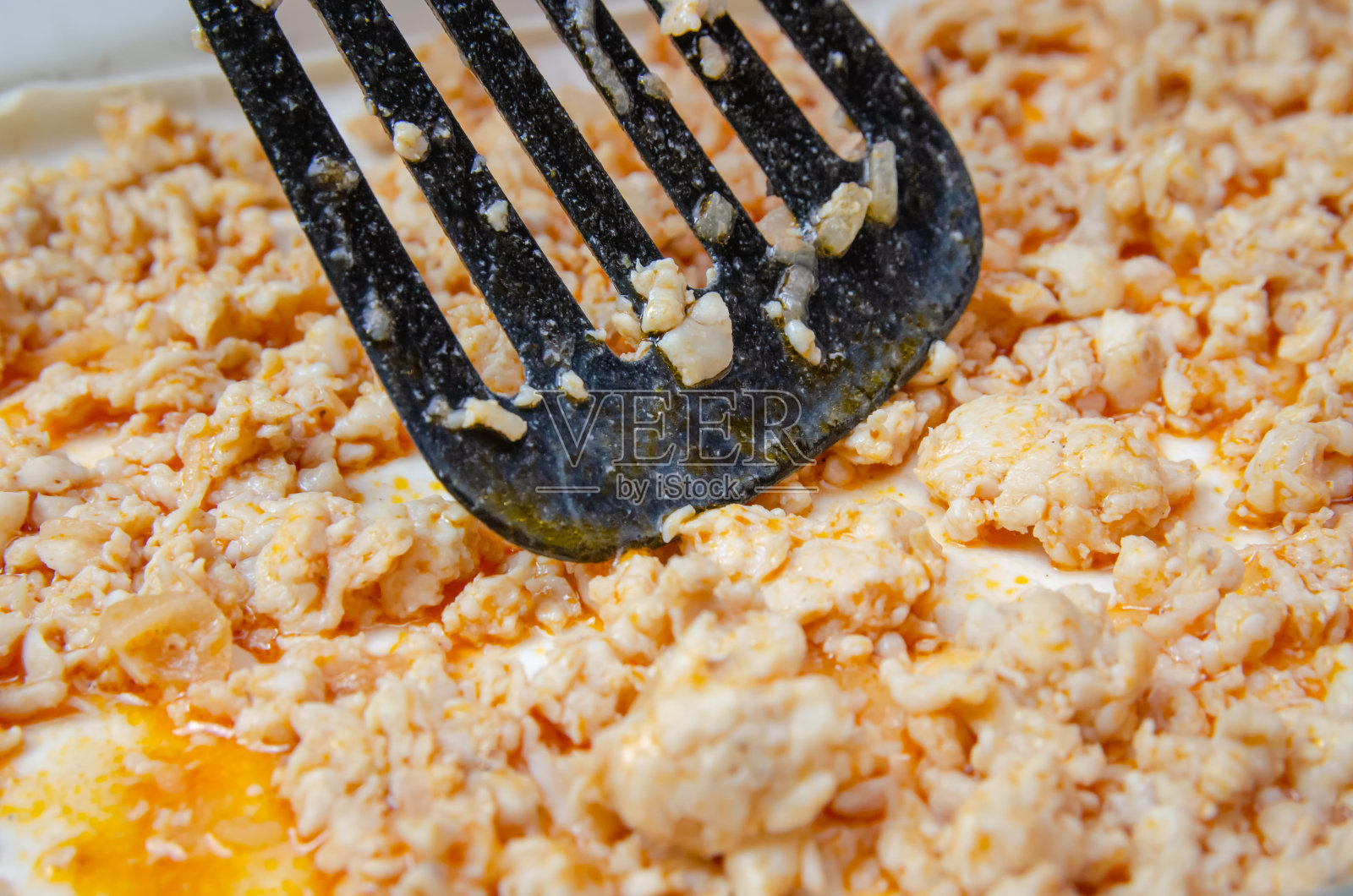 女人准备美味的千层面。在特写镜头中，这位女士用黑色抹刀将碎肉均匀地撒在千层面上照片摄影图片