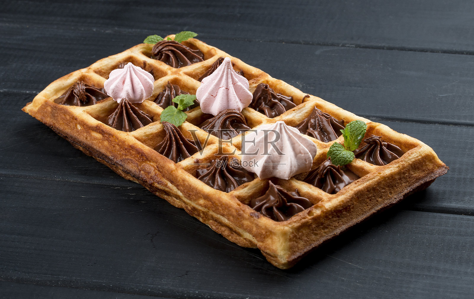 比利时华夫饼配蛋白酥和巧克力奶油。在深色的木制背景上照片摄影图片